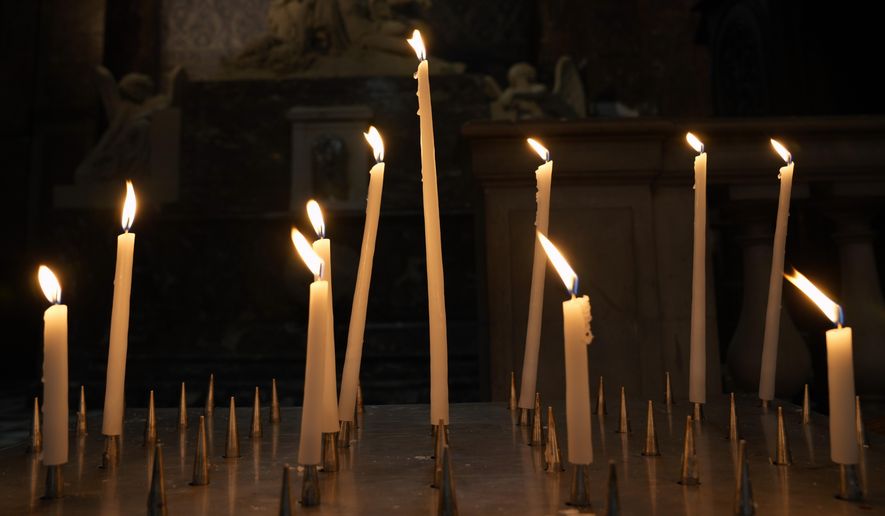 Candles are lighten in a Catholic Church in central Paris, Tuesday, Oct. 5, 2021. The head of France&#39;s Catholic bishops conference is asking forgiveness from the estimated 330,000 victims of child sex abuse by the church found in a groundbreaking report. The report was released Tuesday after extensive research in France&#39;s first major reckoning with the issue. (AP Photo/Francois Mori)