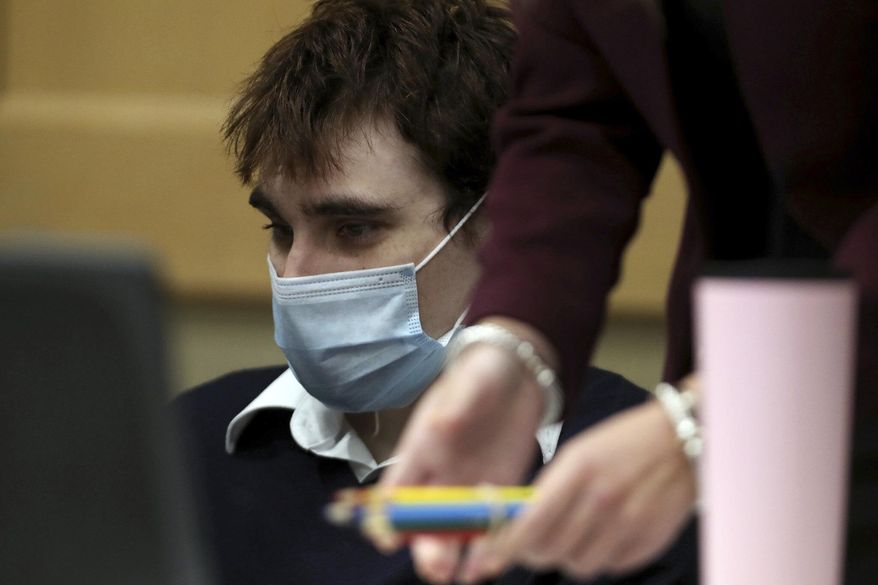 Colored pencils are moved away from Parkland school shooter Nikolas Cruz for safety reasons in court during day two of jury selection in his trial at the Broward County Courthouse in Fort Lauderdale, Fla. on Wednesday, Oct. 6, 2021, on four criminal counts stemming from his alleged attack on a Broward jail guard in November 2018. Cruz is accused of punching Sgt. Ray Beltran, wrestling him to the ground and taking his stun gun. (Amy Beth Bennett/South Florida Sun Sentinel via AP, Pool)