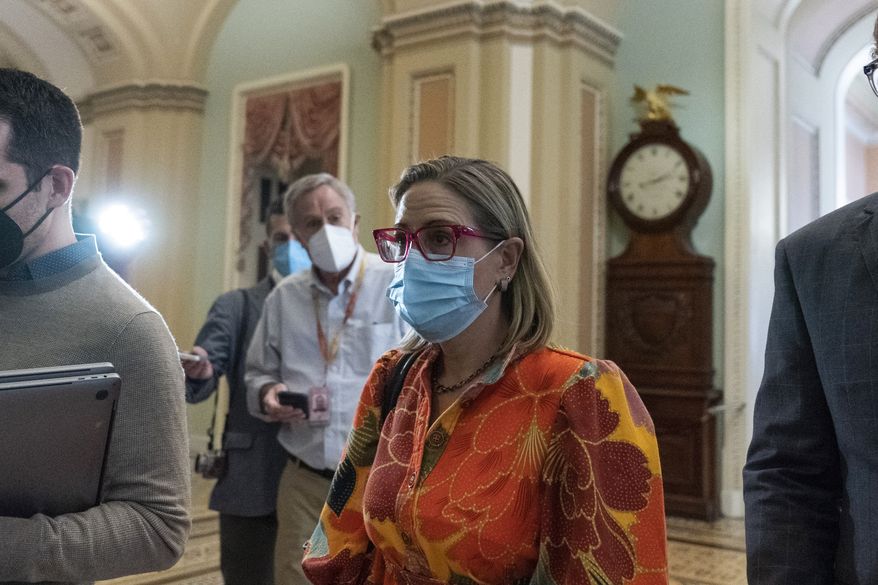 Sen. Kyrsten Sinema, D-Ariz., walks from a policy luncheon on Capitol Hill, Thursday, Oct. 7, 2021, in Washington. (AP Photo/Alex Brandon)