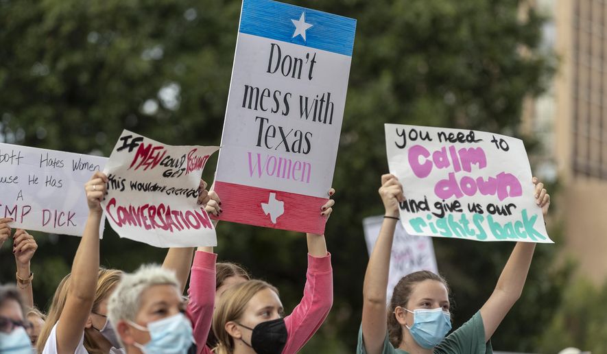 In this Oct. 2, 2021, photo, people attend the Women's March ATX rally, at the Texas State Capitol in Austin, Texas. A federal judge has ordered Texas to suspend a new law that has banned most abortions in the state since September. The order Wednesday by U.S. District Judge Robert Pitman freezes for now the strict abortion law known as Senate Bill 8. (AP Photo/Stephen Spillman) **FILE**
