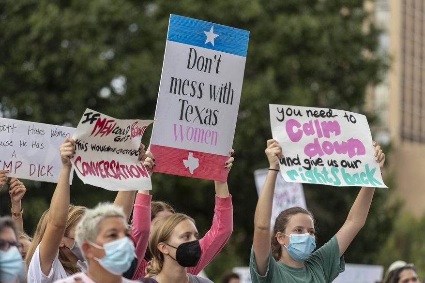 In this Oct. 2, 2021, photo, people attend the Women&#39;s March ATX rally, at the Texas State Capitol in Austin, Texas. A federal judge has ordered Texas to suspend a new law that has banned most abortions in the state since September. The order Wednesday by U.S. District Judge Robert Pitman freezes for now the strict abortion law known as Senate Bill 8. (AP Photo/Stephen Spillman) **FILE**