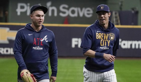 Milwaukee Brewers&#39; Christian Yelich talks to Atlanta Braves&#39; Joc Pederson at a practice for the Game 1 of the NLDS baseball game Thursday, Oct. 7, 2021, in Milwaukee. The Braves plays the Milwaukee Brewers in Game 1 on Friday, Oct. 8, 2021. (AP Photo/Morry Gash) **FILE**