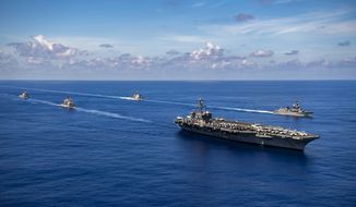 In this photo released by the U.S. Navy, the Nimitz-class aircraft carrier USS Carl Vinson (CVN 70), the Ticonderoga-class guided-missile cruiser USS Lake Champlain (CG 57), and the Arleigh Burke-class guided-missile destroyer USS Chafee (DDG 90) conduct a passing honors ceremony with the Japan Maritime Self-Defense Force (JMSDF) Murasame-class destroyer JS Ikazuchi (DD 107) and the Kongo-class guided-missile destroyer JS Chokai (DDG 176) in the Pacific Ocean, Sept. 19, 2021. A spate of recent Chinese military flights off Taiwan, which Beijing claims as its own, and naval maneuvers by the United States and its allies to reinforce maritime routes challenged by China are fueling increasing tensions in a region already on edge. (Haydn N. Smith/U.S. Navy via AP)