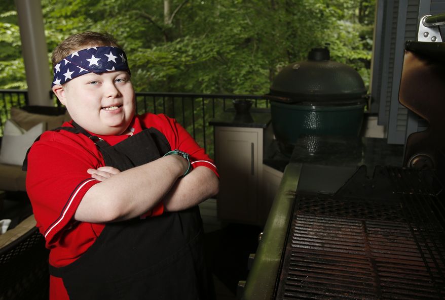 In this Aug. 2, ,2017 photo, Fuller Goldsmith stands at one of three grills on his back porch at his home in Tuscaloosa, Ala. Goldsmith spent much of his early life awaiting chemotherapy treatments at Children's of Alabama hospital, and he got hooked on TV cooking shows. That set him down a path that landed him on Food Network and in kitchens around his native Tuscaloosa. The teen chef died of cancer, Tuesday, Oct. 5, 2021, just days before his 18th birthday. (Erin Nelson/The Tuscaloosa News via AP)