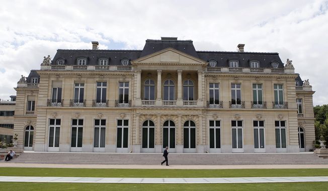 In this June 7, 2017 file photo, the Organisation for Economic Cooperation and Development (OECD) headquarters is pictured in Paris, France. Nearly 140 countries have agreed on a tentative deal that would make sweeping changes to how big, multinational companies are taxed in order to deter them from stashing their profits in offshore tax havens where they pay little or no tax. The agreement announced Friday foresees countries enacting a global minimum corporate tax of 15% on the biggest, internationally active companies. (AP Photo/Francois Mori, File)