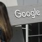 In this Sept. 24, 2019, photo, a woman walks below a Google sign on the campus in Mountain View, Calif.  Google on Thursday, Oct. 7, 2021, will no longer allow digital ads promoting false climate change claims to appear next to the content of other publishers, hoping to deny money to those making such claims and to stop the spread of misinformation on its platform. (AP Photo/Jeff Chiu) **FILE**