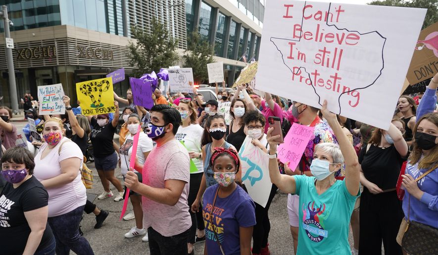 In this Oct. 2, 2021, file photo, people participate in the Houston Women&#x27;s March against Texas&#x27; abortion ban from Discovery Green to City Hall in Houston. (Melissa Phillip/Houston Chronicle via AP, File)