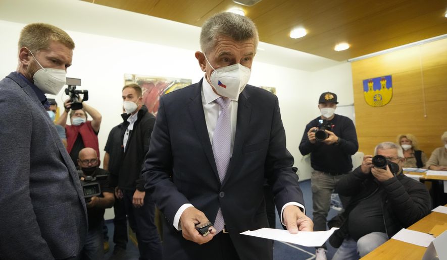 Czech Republic's Prime Minister and leader of centrist ANO (YES) movement Andrej Babis holds his ballot at a polling station in Lovosice, Czech Republic, Friday, Oct. 8, 2021. Czechs begin voting in a parliamentary election with polls showing Prime Minister Andrej Babis, a populist billionaire, has a good chance of keeping his job, despite a new scandal over his financial dealings. (AP Photo/Petr David Josek)