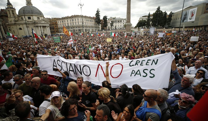 People gather in Piazza del Popolo square during a protest, in Rome, Saturday, Oct. 9, 2021. Thousands of demonstrators protested Saturday in Rome against the COVID-19 health pass that Italian workers, both the public and private sectors, must display to access their workplaces from Oct. 15 under a government decree. (Cecilia Fabiano/LaPresse via AP)