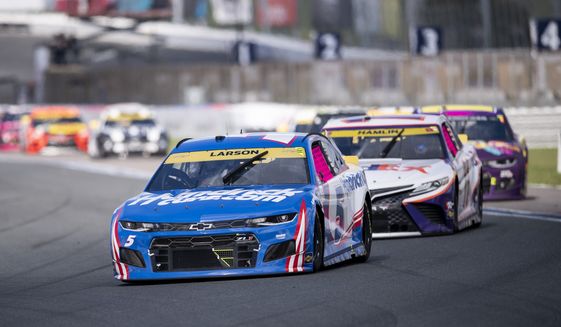Kyle Larson (5) leads a pack of cars during a NASCAR Cup Series auto racing race at Charlotte Motor Speedway, Sunday, Oct. 10, 2021, in Concord, N.C. (AP Photo/Matt Kelley)
