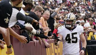 New Orleans Saints tight end Garrett Griffin celebrates with fans after an NFL football game against the Washington Football Team, Sunday, Oct. 10, 2021, in Landover, Md. New Orleans won 33-22. (AP Photo/Alex Brandon)