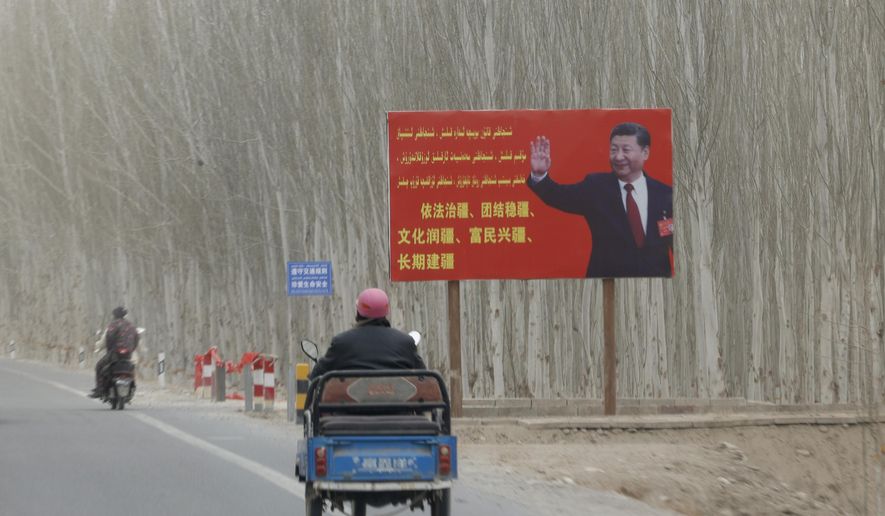 Chinese President Xi Jinping is seen on a billboard with the slogan, &amp;quot;Administer Xinjiang according to law, unite and stabilize the territory, culturally moisturize the territory, enrich the people and rejuvenate the territory, and build the territory for a long term,&amp;quot; in Yarkent County in northwestern China&#x27;s Xinjiang Uyghur Autonomous Region on March 21, 2021. Four years after Beijing&#x27;s brutal crackdown on largely Muslim minorities native to Xinjiang, Chinese authorities are dialing back the region&#x27;s high-tech police state and stepping up tourism. But even as a sense of normality returns, fear remains, hidden but pervasive. (AP Photo/Ng Han Guan)