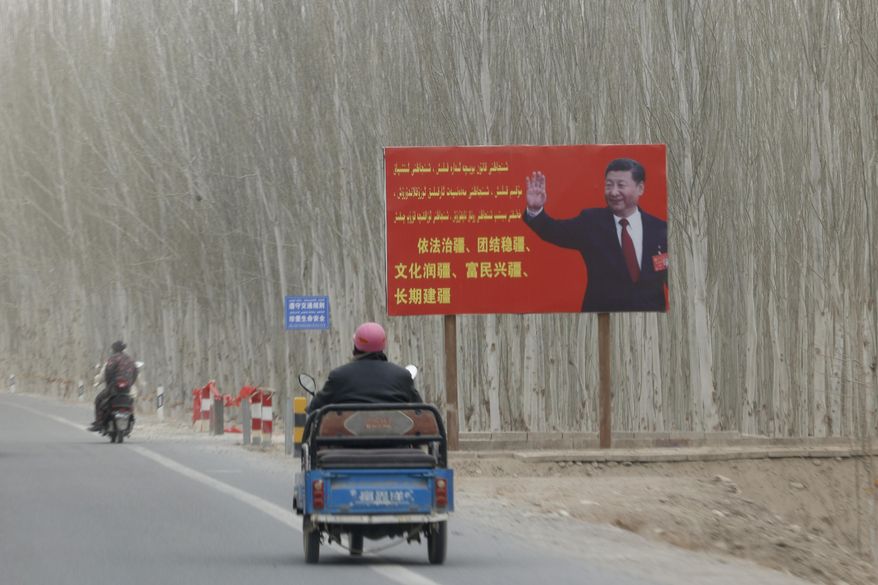 Chinese President Xi Jinping is seen on a billboard with the slogan, &amp;quot;Administer Xinjiang according to law, unite and stabilize the territory, culturally moisturize the territory, enrich the people and rejuvenate the territory, and build the territory for a long term,&amp;quot; in Yarkent County in northwestern China&#39;s Xinjiang Uyghur Autonomous Region on March 21, 2021. Four years after Beijing&#39;s brutal crackdown on largely Muslim minorities native to Xinjiang, Chinese authorities are dialing back the region&#39;s high-tech police state and stepping up tourism. But even as a sense of normality returns, fear remains, hidden but pervasive. (AP Photo/Ng Han Guan)