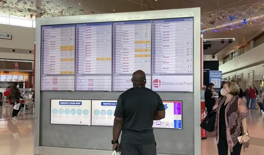 In this frame grab from cellphone video, passengers look for information on their flights, Sunday, Oct. 10, 2021, at Dallas Love Field. Southwest Airlines canceled hundreds of flights over the weekend, blaming the woes on air traffic control issues and weather. (AP Photo/Julie March)