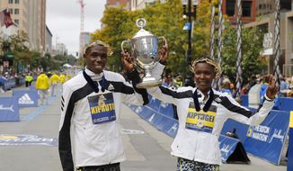 Benson Kipruto, left, and Diana Kipyogei, both of Kenya, celebrate winning the men&#39;s and women&#39;s divisions of the 125th Boston Marathon on Monday, Oct. 11, 2021, in Boston. (AP Photo/Winslow Townson)