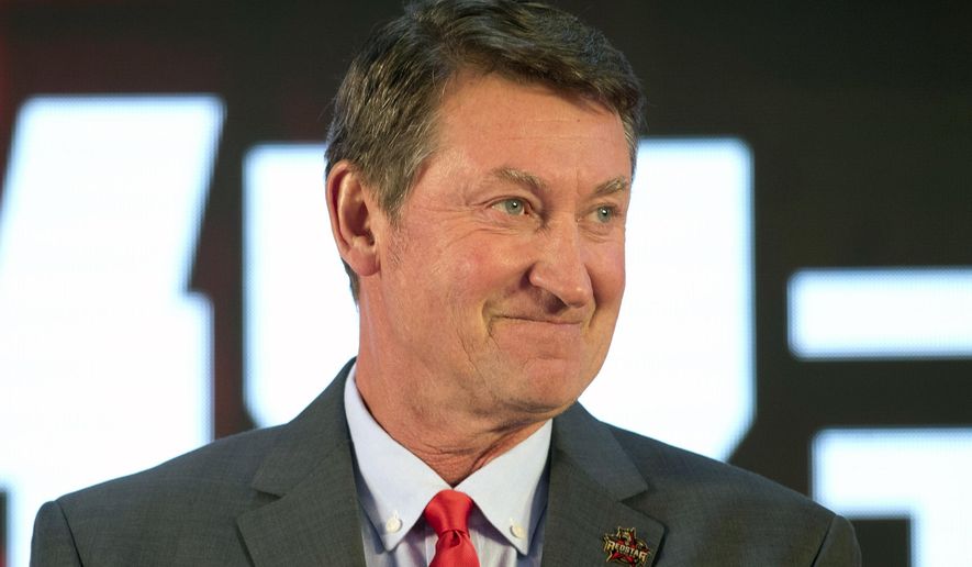 FILE - Former NHL hockey player Wayne Gretzky smiles during a promotional event for the Beijing Kunlun Red Star hockey team in Beijing, in this Thursday, Sept. 13, 2018, file photo. Alex Ovechkin starts a new five-year contract ready to chase Gretzky&#39;s career goals record that long seemed unbreakable. The Washington Capitals captain has 730 goals and needs 165 to pass Gretzky.  (AP Photo/Mark Schiefelbein, File)