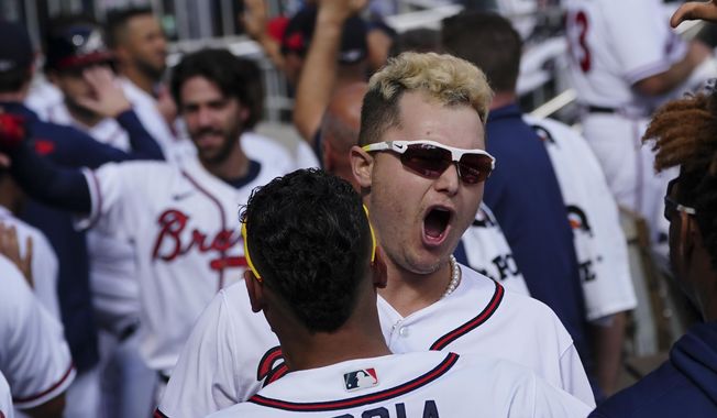 Atlanta Braves&#x27; Joc Pederson (22) celebrates his three-run homer in the dugout against the Milwaukee Brewers during the fifth inning of Game 3 of a baseball National League Division Series, Monday, Oct. 11, 2021, in Atlanta. (AP Photo/John Bazemore)