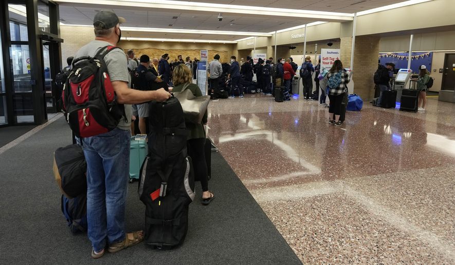 Passengers queue up at the ticketing counter for Southwest Airlines flights in Eppley Airfield Sunday, Oct. 10, 2021, in Omaha, Neb. Southwest Airlines canceled hundreds of flights over the weekend, blaming the woes on air traffic control issues and weather. (AP Photo/David Zalubowski)