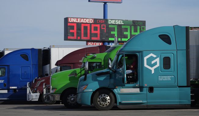 Cost of gasoline and diesel is displayed on an electronic sign hanging over a line of long-haul trucks parked at a stop off Interstate 90 Friday, Oct. 8, 2021, in Mitchell, S.D. (AP Photo/David Zalubowski)