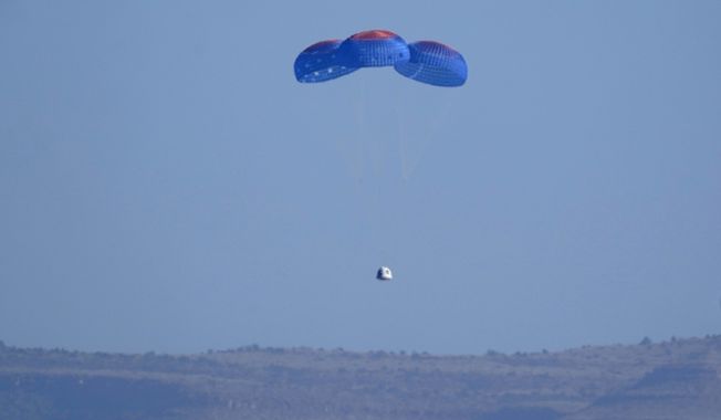 Parachutes carry the Blue Origin capsule with passengers William Shatner, Chris Boshuizen, Audrey Powers and Glen de Vries down to the spaceport near Van Horn, Texas, Wednesday, Oct. 13, 2021. (AP Photo/LM Otero)