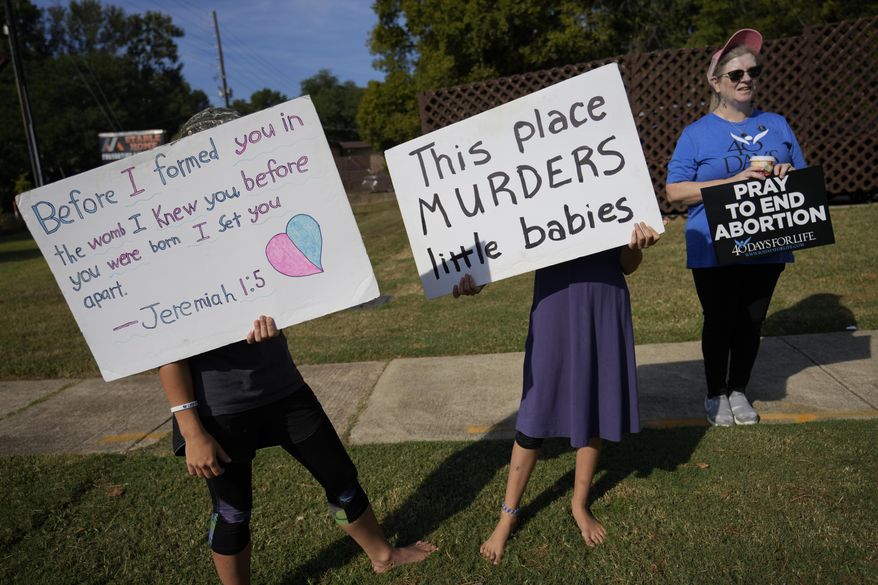 Anti-abortion protesters, including two adolescent girls, hold signs as they stand outside Hope Medical Group for Women, Saturday, Oct. 9, 2021, in Shreveport, La. As most of the women entered the clinic's parking lot, they were met by two groups of anti-abortion protesters, mostly men from East Texas who regularly make the trip to Shreveport. (AP Photo/Rebecca Blackwell) ** FILE **