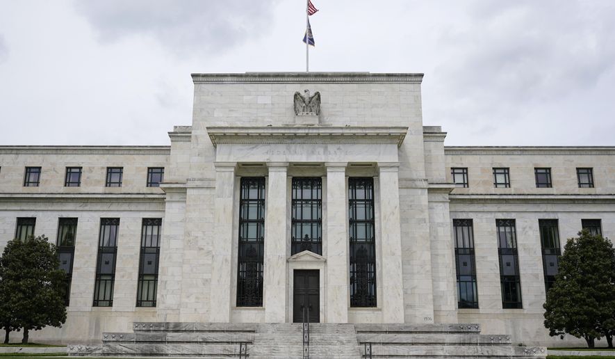 This May 4, 2021, file photo shows the Federal Reserve building in Washington. Federal Reserve officials agreed at their last meeting that if the economy continued to improve, they could start reducing their monthly bond purchases as soon as next month and bring them to an end by the middle of 2022. The discussion was revealed in the minutes of the Fed’s Sept. 21-22 meeting, released Wednesday, Oct. 13, 2021. (AP Photo/Patrick Semansky, File)