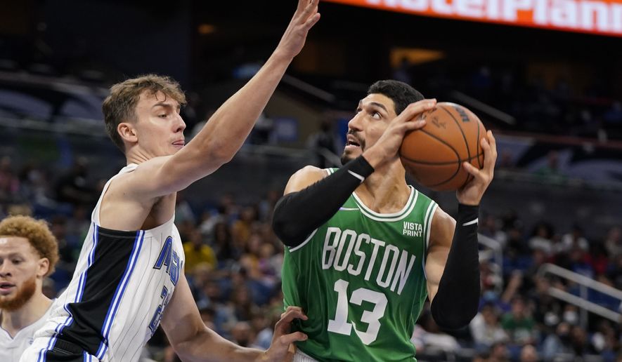 Boston Celtics' Enes Kanter (13) attempts a shot against Orlando Magic's Franz Wagner, left, during the second half of an NBA preseason basketball game, Wednesday, Oct. 13, 2021, in Orlando, Fla. (AP Photo/John Raoux)