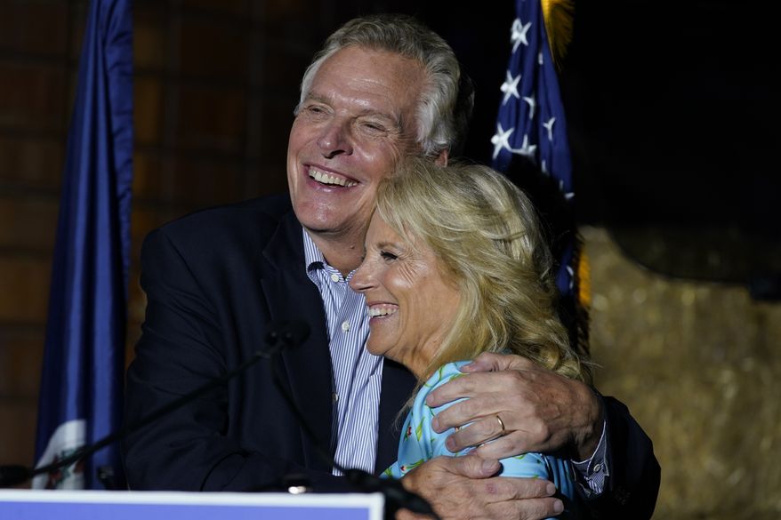 First lady Jill Biden, right, gets a hug from Democratic gubernatorial candidate Terry McAuliffe during a rally in Richmond, Va., Friday, Oct. 15, 2021. McAuliffe will face Republican Glenn Youngkin in the November election. (AP Photo/Steve Helber)