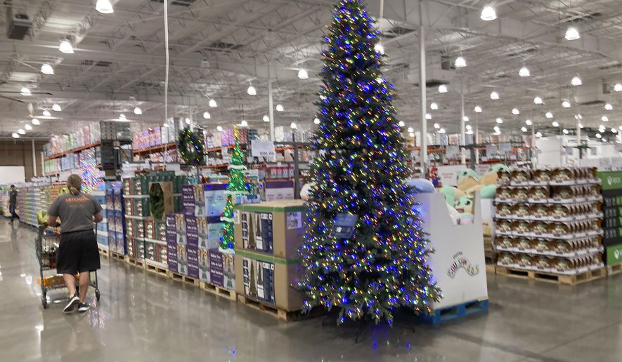 A lone shopper pushes a cart past a display for Christmas sales in a Costco warehouse late Thursday, Sept. 23, 2021, in Lone Tree, Colo. Companies that typically hire thousands of seasonal workers are heading into the holidays during one of the tightest job markets in decades, making it unlikely they’ll find all the workers they need. For shoppers, it might mean a less than jolly holiday shopping experience, with bare store shelves and online orders that take longer than usual to fill.  (AP Photo/David Zalubowski)