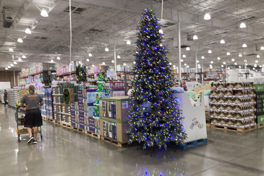 A lone shopper pushes a cart past a display for Christmas sales in a Costco warehouse late Thursday, Sept. 23, 2021, in Lone Tree, Colo. Companies that typically hire thousands of seasonal workers are heading into the holidays during one of the tightest job markets in decades, making it unlikely they’ll find all the workers they need. For shoppers, it might mean a less than jolly holiday shopping experience, with bare store shelves and online orders that take longer than usual to fill. (AP Photo/David Zalubowski)