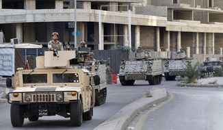 Lebanese army soldiers on armed vehicles patrol, in Ain el-Remaneh neighborhood, Beirut, Lebanon, Friday, Oct. 15, 2021. Lebanese authorities freed Wednesday a freelance American journalist who was detained in Beirut last month. The release came just hours after two international human rights groups called her detention arbitrary and demanded that she be set free. (AP Photo/Bilal Hussein)