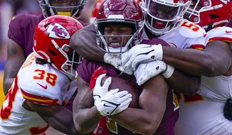 Washington Football Team running back Antonio Gibson (24) clutches the football as he is tackled by Kansas City Chiefs outside linebacker Nick Bolton (54) during the first half of an NFL football game, Sunday, Oct. 17, 2021, in Landover, Md. (AP Photo/Alex Brandon)