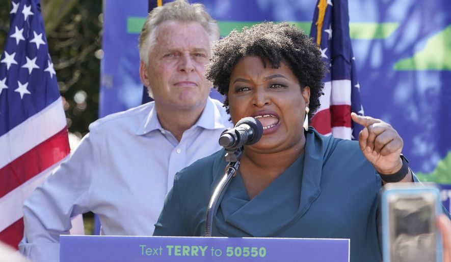 Voting rights activist Stacey Abrams, right, she speaks during a rally with Democratic gubernatorial candidate, former Virginia Gov. Terry McAuliffe, left, in Norfolk, Va., Sunday, Oct. 17, 2021. Abrams was in town to encourage voters to vote for the Democratic gubernatorial candidate in the November election. (AP Photo/Steve Helber)