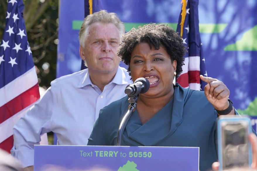 Voting rights activist Stacey Abrams, right, she speaks during a rally with Democratic gubernatorial candidate, former Virginia Gov. Terry McAuliffe, left, in Norfolk, Va., Sunday, Oct. 17, 2021. Abrams was in town to encourage voters to vote for the Democratic gubernatorial candidate in the November election. (AP Photo/Steve Helber)