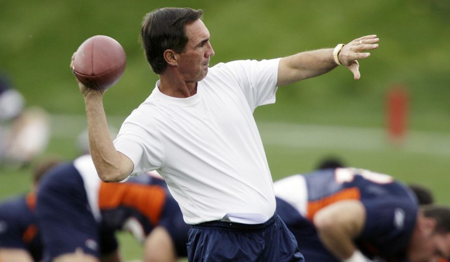 In this Oct. 2, 2006, file photo, Denver Broncos head coach Mike Shanahan passes the ball as he waits for the start of the team&#x27;s first football practice after a bye week  in Englewood, Colo. The Broncos will honor Shanahan, the winningest coach in the team&#x27;s history, by including his name in the Ring of Fame during a halftime ceremony Sunday, Oct. 17, 2021, when the team hosts the Las Vegas Raiders in an NFL football game. (AP Photo/David Zalubowski, File) **FILE**