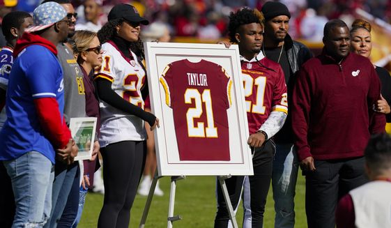 Family members of the late Sean Taylor gather on the field as the Washington Football Team retire his jersey during a halftime ceremony at an NFL football game against the Kansas City Chiefs, Sunday, Oct. 17, 2021, in Landover, Md. (AP Photo/Patrick Semansky)