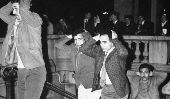 FILE - In this Oct.17, 1967 file photo, Algerians come out of Paris subway station with their hands on their heads after being arrested in Paris for failure to obey curfew imposed on Algerians. A tribute march is organized in Paris Sunday Oct.17, 2021 for the 60th anniversary of the bloody police crackdown on a protest by Algerians in the French capital, during the final year of their country&#39;s independence war with the colonial power. About 12,000 Algerians were arrested and &amp;quot;several dozens&amp;quot; were killed, &amp;quot;their bodies thrown into the Seine River.&amp;quot; Historians say at least 120 protesters have been killed, some shot and some drowned in the Seine River. (AP Photo, File)