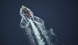 Migrants navigate on an overcrowded wooden boat in the Central Mediterranean Sea between North Africa and the Italian island of Lampedusa, Saturday, Oct. 2, 2021, as seen from aboard the humanitarian aircraft Seabird. At least 23,000 people have died or disappeared trying to reach Europe since 2014, according to the United Nations&#39; migration agency. Despite the risks, many migrants say they&#39;d rather die trying to reach Europe than be returned to Libya. (AP Photo/Renata Brito)