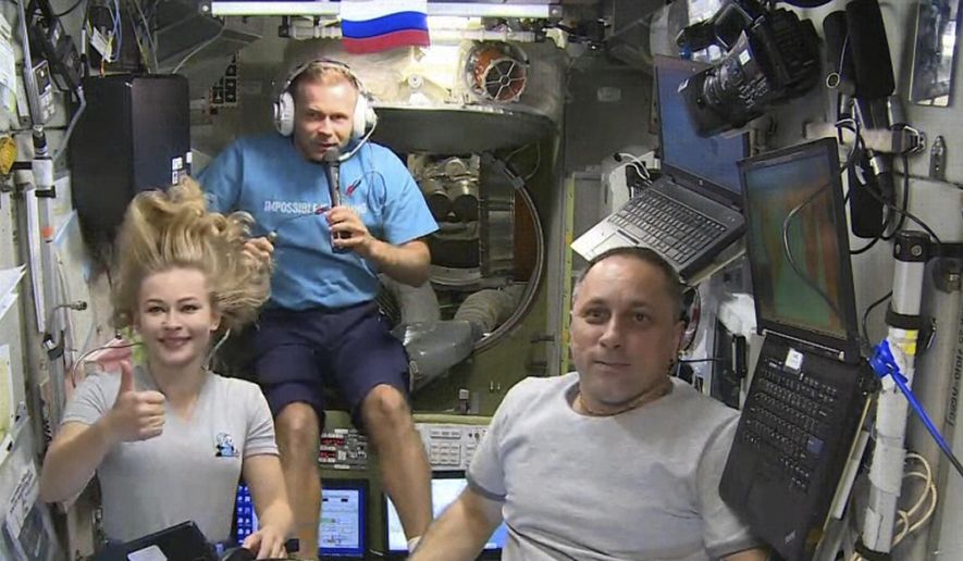 FILE - In this Oct. 7, 2021, file photo taken from video footage released by Roscosmos Space Agency, actress Yulia Peresild, left, film director Klim Shipenko, center, and cosmonaut Anton Shkaplerov speak with the Moscow Mission Control Center from the International Space Station, ISS. A Soyuz space capsule carrying a cosmonaut and two Russian filmmakers has separated from the International Space Station and is heading for the Earth. The separation took place on schedule at 0115 GMT Sunday, Oct. 17, with Oleg Novitskiy, Yulia Peresild and Klim Shipenko aboard for a descent of about 3 1/2 hours. (Roscosmos Space Agency via AP, File)