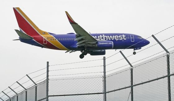 A Southwest Airlines flight lands at General Mitchell International Airport, Wednesday, Oct. 13, 2021, in Milwaukee. Southwest will let unvaccinated employees keep working past early December instead of putting them on unpaid leave if they apply for an exemption on medical or religious grounds. (AP Photo/Morry Gash)