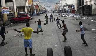 Youths play soccer next to businesses that are closed due to a general strike in Port-au-Prince, Haiti, Monday, Oct. 18, 2021. Workers angry about the nation&#39;s lack of security went on strike in protest two days after 17 members of a US-based missionary group were abducted by a violent gang. (AP Photo/Matias Delacroix)