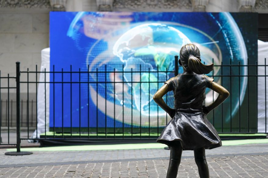 The Fearless Girl statue is seen in front of a video screen displaying the image of the earth outside the New York Stock Exchange, Tuesday, Oct. 5, 2021, in New York. Stocks are moving modestly higher on Wall Street in early trading Tuesday, Oct. 19, 2021 as corporate earnings reporting gets into full swing. The benchmark S&P 500 was up 0.3% in the first few minutes of trading, and the Dow Jones Industrial Average was up 0.2%. Health care companies were making some of the biggest gains in the early going. (AP Photo/Mary Altaffer, file)