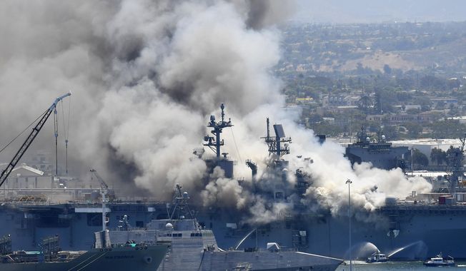 FILE - In this July 12, 2020, file photo, smoke rises from the USS Bonhomme Richard at Naval Base San Diego in San Diego, after an explosion and fire on board the ship at Naval Base San Diego. A Navy report has concluded there were sweeping failures by commanders, crew members and others that fueled the July 2020 arson fire that destroyed the USS Bonhomme Richard, calling the massive five-day blaze in San Diego preventable and unacceptable. While one sailor has been charged with setting the fire, the more than 400-page report, obtained by The Associated Press, lists three dozen officers and sailors whose failings either directly led to the ship&#x27;s loss or contributed to it. (AP Photo/Denis Poroy, File)
