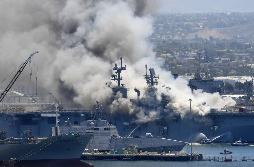 FILE - In this July 12, 2020, file photo, smoke rises from the USS Bonhomme Richard at Naval Base San Diego in San Diego, after an explosion and fire on board the ship at Naval Base San Diego. A Navy report has concluded there were sweeping failures by commanders, crew members and others that fueled the July 2020 arson fire that destroyed the USS Bonhomme Richard, calling the massive five-day blaze in San Diego preventable and unacceptable. While one sailor has been charged with setting the fire, the more than 400-page report, obtained by The Associated Press, lists three dozen officers and sailors whose failings either directly led to the ship&#39;s loss or contributed to it. (AP Photo/Denis Poroy, File)