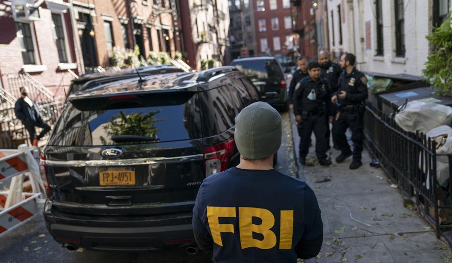 A federal agent stands in front of property connected to Russian oligarch Oleg Deripaska as members of the New York Police Department patrol the area, Tuesday, Oct. 19, 2021, in New York. More than half of Republican voters believe the FBI is acting as President Biden's personal secret state police, according to a poll released Tuesday. (AP Photo/John Minchillo)
