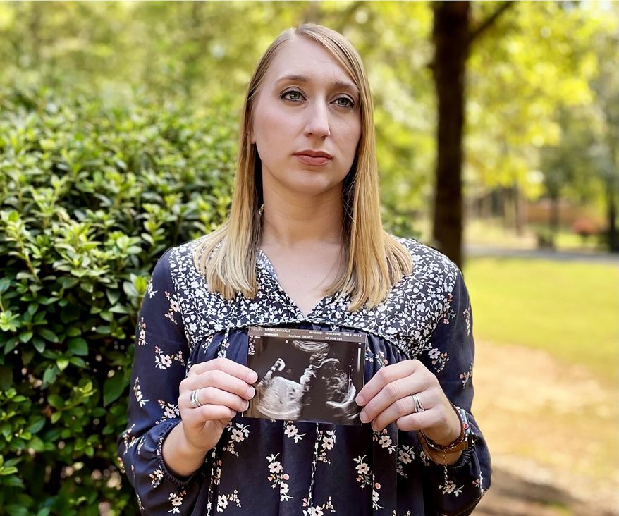 Kyndal Nipper, of Midland, Ga., who suffered a stillbirth after becoming ill with COVID-19 in her third trimester, holds an ultrasound image of the son she lost while standing outside her home on Friday, Oct. 15, 2021. Nipper, who was unvaccinated, is encouraging women to get vaccinated. (AP Photo/Kim Chandler)