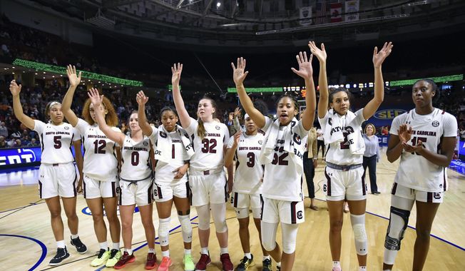 FILE - In this March 6, 2020, file photo, South Carolina players celebrate after defeating Georgia 89-56 in a quarterfinal match at the Southeastern women&#x27;s NCAA college basketball tournament in Greenville, S.C. Dawn Staley and South Carolina are back in a familiar spot: No. 1 in The Associated Press Top 25 women&#x27;s basketball poll, released Tuesday, Oct. 19, 2021.(AP Photo/Richard Shiro, File) **FILE**