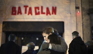 In this Nov. 13, 2016, file photo, women hug in front of the Bataclan concert hall in Paris. For more than two weeks, dozens of survivors from the Bataclan concert hall in Paris have testified in a specially designed courtroom about the Islamic States attacks on Nov. 13, 2015, the deadliest in modern France. The testimony marks the first time many survivors are describing and learning what exactly happened that night at the Bataclan, filling in the pieces of a puzzle that is taking shape as they speak. (AP Photo/Thibault Camus, File)