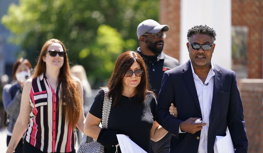 Former NFL players Ken Jenkins, right, and Clarence Vaughn III, center right, along with their wives, Amy Lewis, center, and Brooke Vaughn, left, carry tens of thousands of petitions demanding equal treatment for everyone involved in the settlement of concussion claims against the NFL, to the federal courthouse in Philadelphia, in this Friday, May 14, 2021, file photo. Lawyers for the NFL and retired players are due to file proposed changes to the $1 billion concussion settlement on Wednesday, Oct. 20, 2021, to remove race-norming in dementia testing, which made it more difficult for Black players to qualify for payments. (AP Photo/Matt Rourke, File)