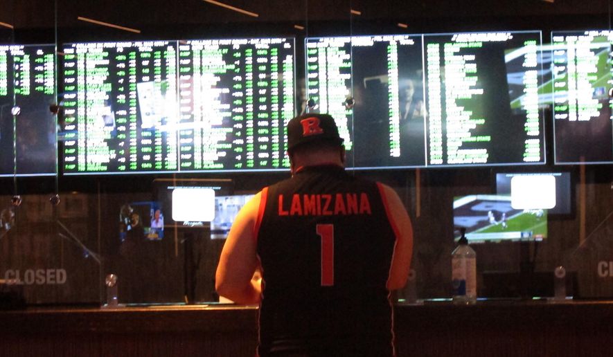 In this Friday, March 19, 2021, file photo, a man makes a sports bet at the Borgata casino in Atlantic City, N.J. On Wednesday, Oct. 20, 2021, the NFL announced it is spending $6.2 million on a responsible betting program with the National Council on Problem Gambling to teach people how to bet on sports responsibly and to fund and expand treatment and prevention programs for compulsive gambling.(AP Photo/Wayne Parry, File) **FILE**